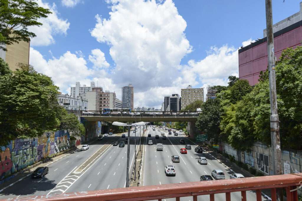 Avenida Radial Leste, em São Paulo. Carros circulam em duas direções abaixo de uma ponte.