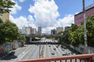 Avenida Radial Leste, em São Paulo. Carros circulam em duas direções abaixo de uma ponte.