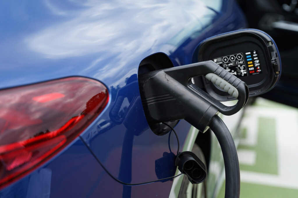 Carro elétrico conectado a uma estação de carregamento, deixando em evidência as baterias em veículos elétricos